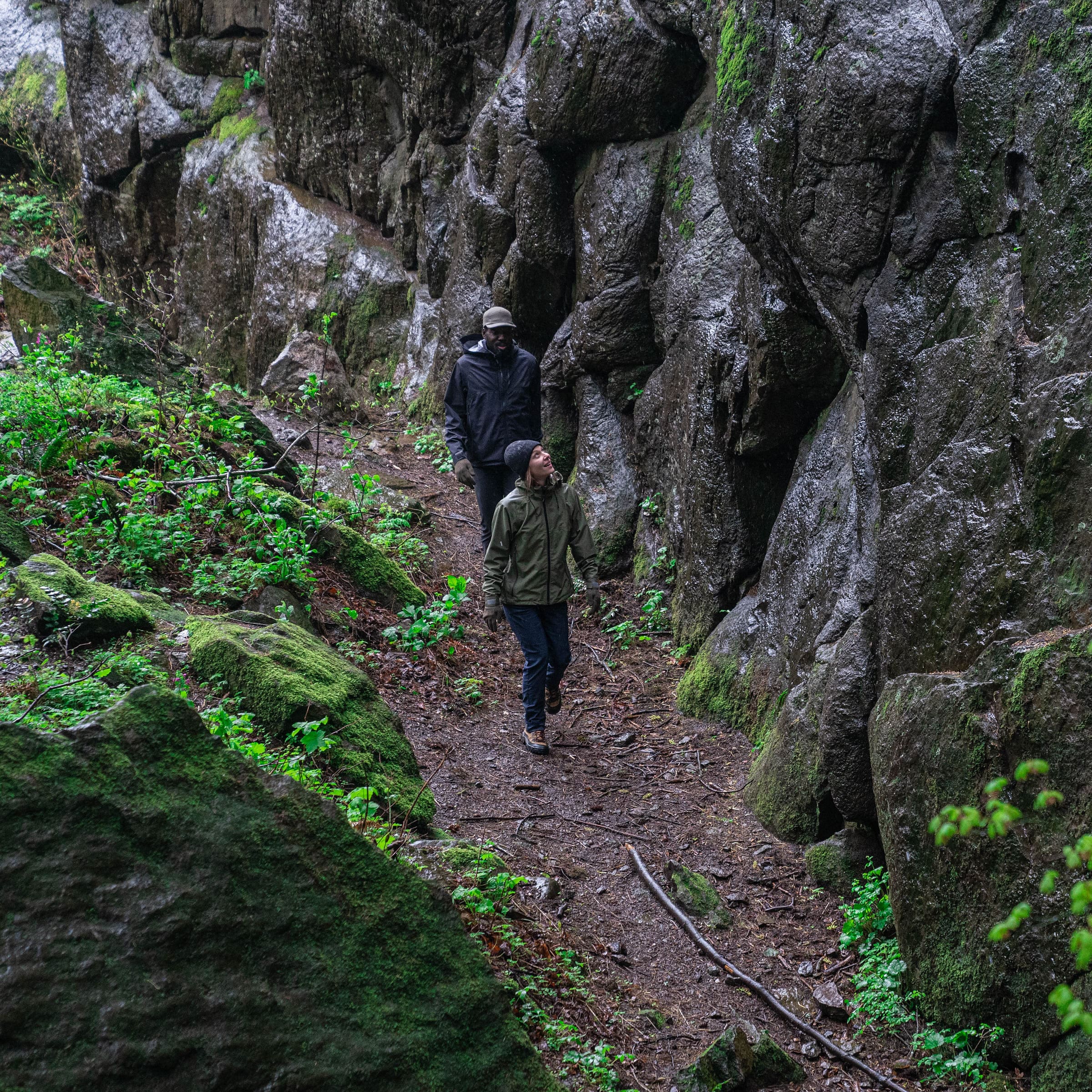 A man and woman hiking in the rain wearing Showers Pass waterproof clothing