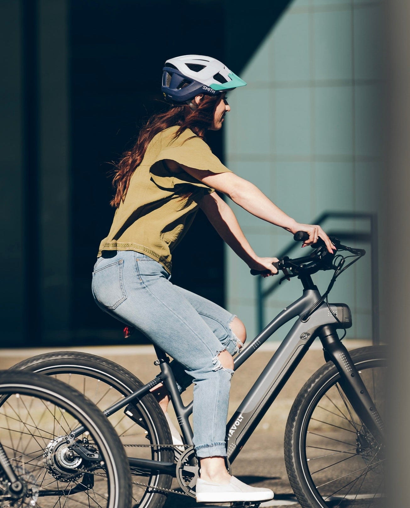 A side shot of a woman riding a grey colored ebike by Vvolt